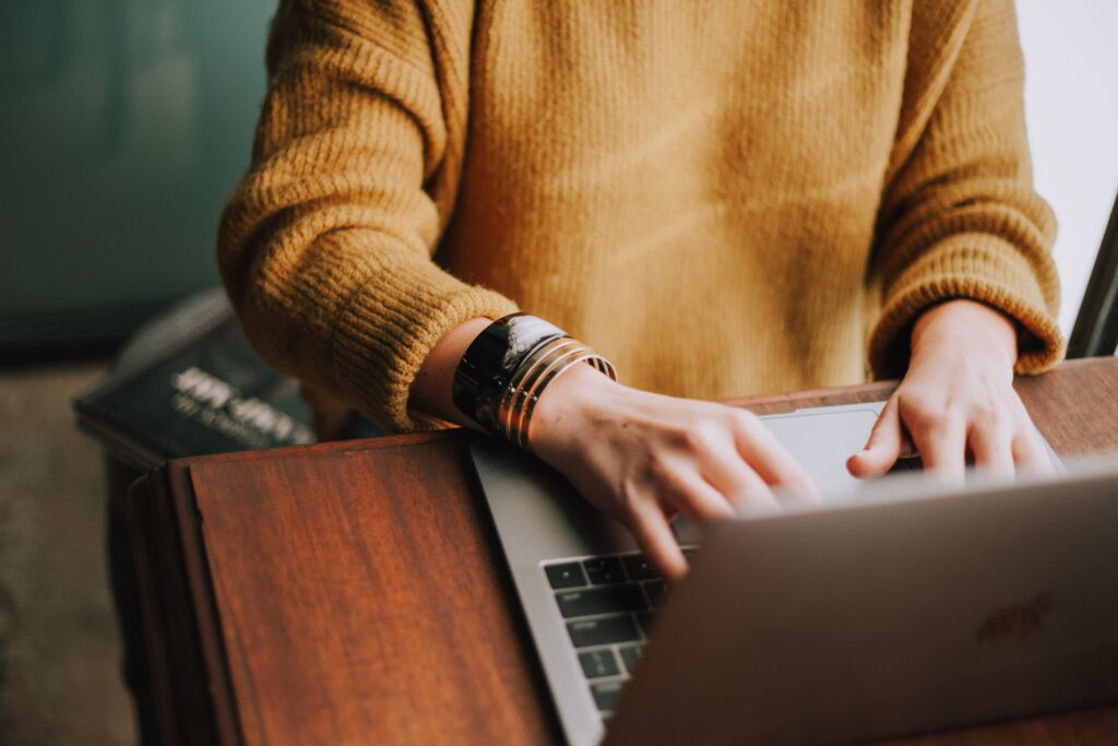 Eine Frau sitzt am Laptop. Wir zeigen dir, welche Vorteile die Digitalisierung des B2B-Vertriebs bringt.